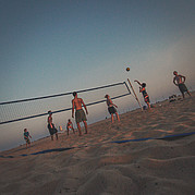 Beachvolleyboll på stranden framför bungalows