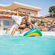 Surfcamp-gäster kopplar av på en uppblåsbar enhörning i poolen vid boendet på Fuerteventura.